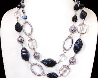 Collana a doppio giro nera e grigia con un mix di perle testurizzate in vetro, acrilico, conchiglia e argento. Collana a strati alla moda.