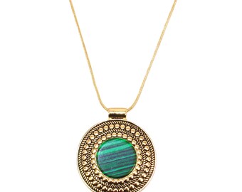 Gold disk pendant with green stone center and with an all raised gold beaded design on the pendant.