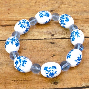 Pulsera elástica con cuentas de porcelana genuina azul con bonitas flores azules y cuentas de vidrio azul. Pulsera de cuentas de flores azules.