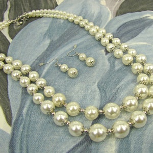 Double row pearl necklace and matching earrings, created with white faux pearls and silver tone beads.  Timeless multi row pearl neck set.
