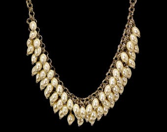 White bead statement necklace created with oval shape white faux pearl beads in a fringe beaded design.