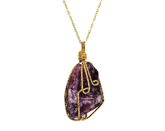 Large organic cut purple amethyst stone pendant wrapped in gold wire swirl and attached to a gold plated chain. .