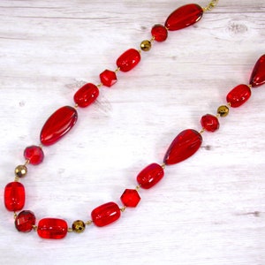 Red beaded necklace with a mix of various shaped beads made in acrylic with a combination of dark and some semi transparent beads.
