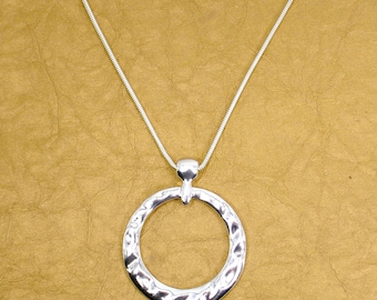 Large shiny round silver pendant necklace with a hammered finish attached to a silver snake chain.  Solid pendant is 2.15" diameter.