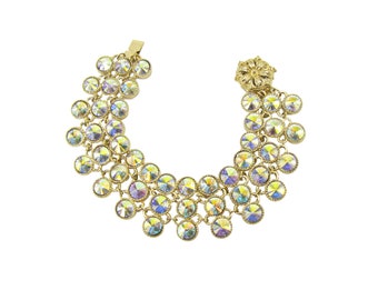 Clear crystal bracelet with an aurora borealis finish. It is designed with three rows of round shape crystals linked together