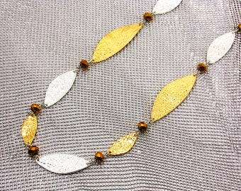 Long silver and gold necklace with metal hammered textured pieces and copper color glass beaeds linked together.  Multi color necklace.