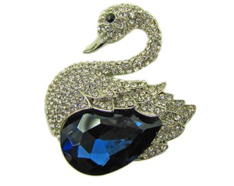 Large sparkling swan pin designed with clear crystals and a large sapphire blue color teardrop shape crystal.