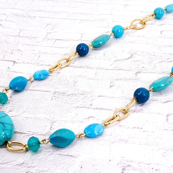 Turquoise beaded necklace with gold plated links and with acrylic beads in various shapes and round stone beads.