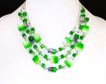 Green multi strand beaded necklace created with a mix of green shell, green glass beads, and silver plated beads.