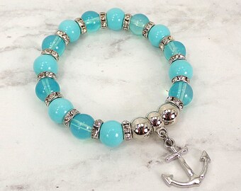 Anchor charm bracelet with turquoise glass beads, turquoise porcelain beads, silver plated beads, and crystal spacer beads.