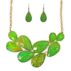 A beautiful green statement necklace and earring set designed with green facet cut resin sections and with gold foil inside.