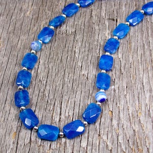 Blue color agate stone bead necklace designed with a mix of small silver beads and round glass beads.