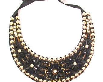 Black glass beaded fabric backed necklace with crystal flower designs, clear crystals, and gold beaded trim.