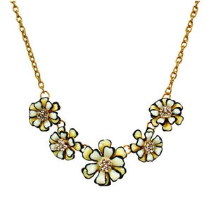 Black and white flower necklace in off white enamel and clear crystals made with five flowers linked together attached to a gold link chain.