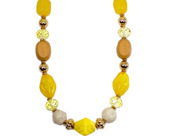 Yellow, brown and gold bead necklace designed with a mix of large beads made in wood, acrylic, glass, and steel.