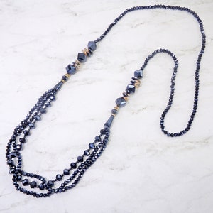 Blue long glass beaded necklace created with blue facet cut glass beads and accented with topaz color glass beads and crystal spacer beads.