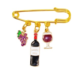 Wine theme pin brooch with dangling charms created in a gold safety pin with grapes, wine bottle, and wine glass charm.