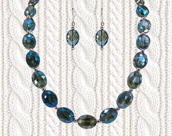 Blue color glass bead necklace and earring set with oval beads and silver beads and with a sparkling aurora borealis finish on each bead