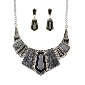 May include: A silver necklace with a geometric design featuring black and gray accents. The necklace is paired with matching earrings.
