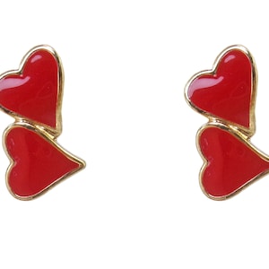 Precious red heart earrings created with double red hearts, gold tone trim and in a shiny finish. Perfect Valentine&#39;s Day earrings..