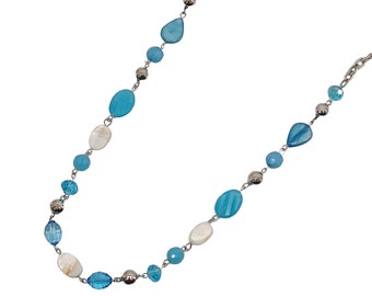 Lunga collana di perline color turchese con un mix di perle di vetro, perle di conchiglia, perle acriliche e perle d'argento, tutte legate tra loro.