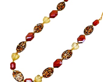 Collana con stampa animalier e perline di vetro marrone realizzata con perline ovali con stampa animalier, perline di vetro marrone e beige e piccole perline dorate