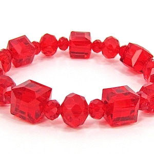 May include: A red crystal bracelet with faceted beads. The bracelet is made of square and round beads.