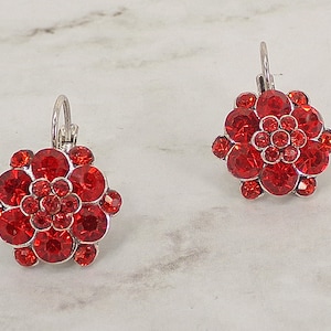 Rode kristallen bloemoorbellen gemaakt met lagen ronde granaatrode kristallen in een verzilverde setting. Rode bloem sieraden oorbellen.