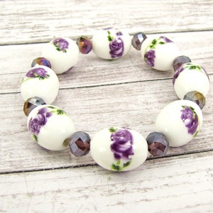 Genuine porcelain beaded stretch bracelet with pretty purple flowers and purple facet cut glass beads.  Purple flower beaded bracelet.