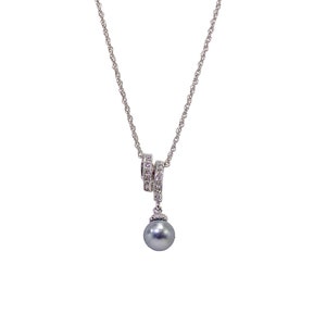 Elegant round gray pearl pendant necklace suspended from a double crystal bail.