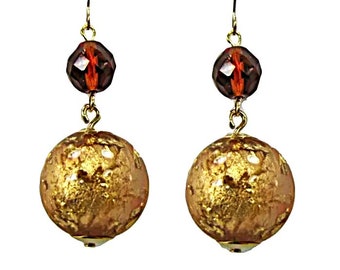 Brincos redondos de resina de folha de ouro com contas de vidro lapidadas na faceta marrom. Brincos femininos da moda na cor dourada.