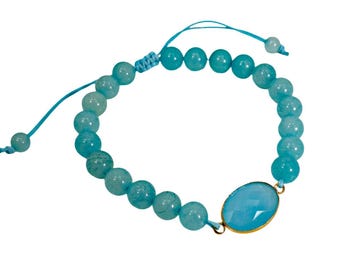 Turquoise color glass bead bracelet made with round beads and an oval flat bead in front and with adjustable length string cord.