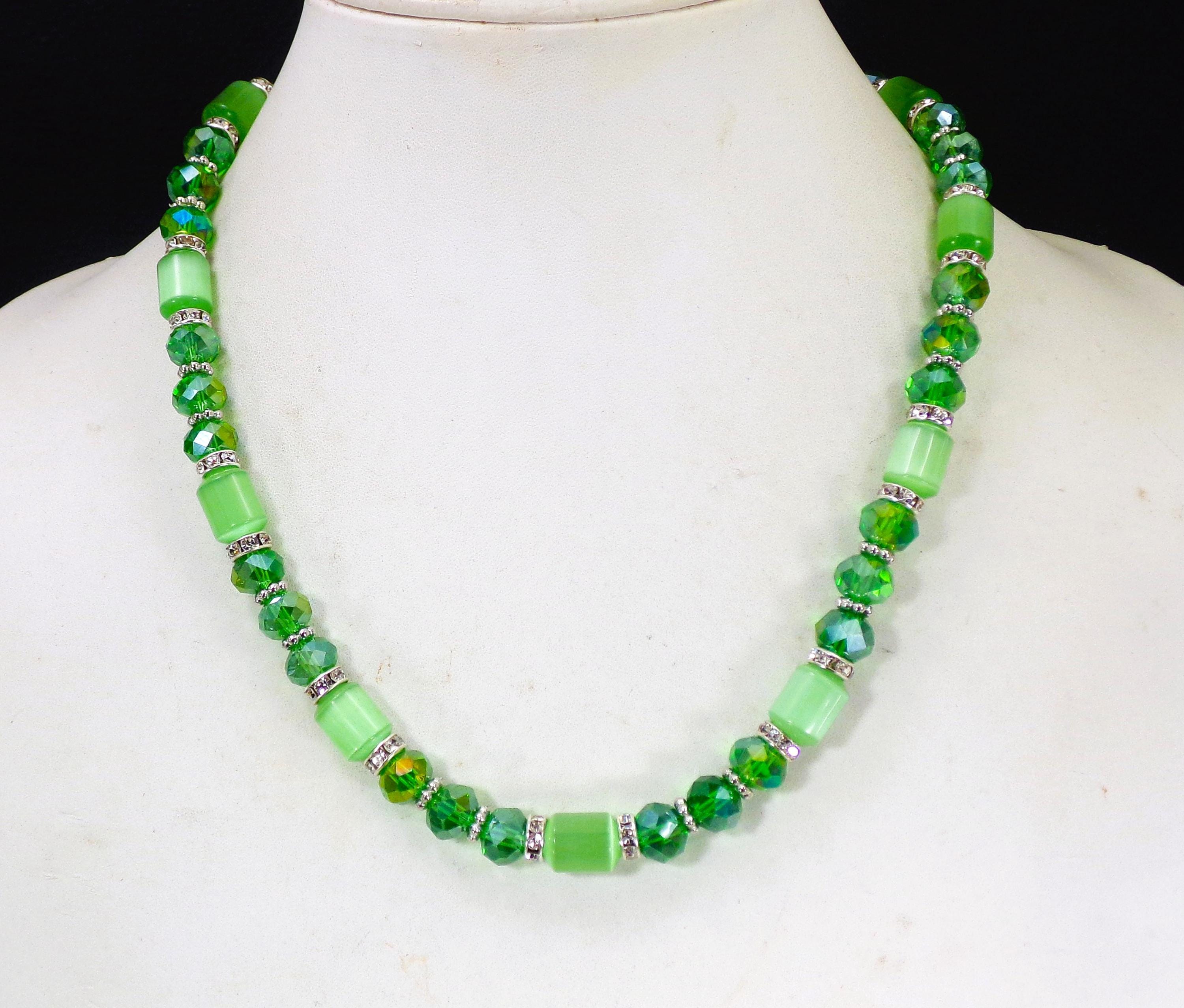 Set composto da collana e orecchini con perline di vetro verde e occhio di gatto, abbinati a perline distanziatrici in cristallo trasparente. - Italia