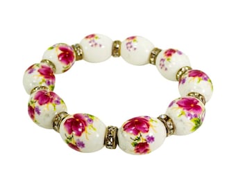 Red and green flower bead stretch bracelet with oval porcelain beads and crystal spacer beads.