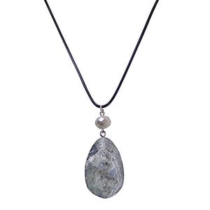 Puede incluir: Un collar con colgante que presenta una piedra grande, en forma de lágrima, de color gris verdoso con apariencia veteada. La piedra cuelga de un cordón negro, con una cuenta facetada más pequeña encima. Diseño sencillo y elegante.