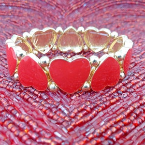 Bracelet extensible en forme de coeur en émail rouge créé avec des perles et des garnitures en émail rouge et dorés. Les breloques cœurs rouges font tout le tour du bracelet. image 3