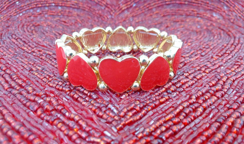 Bracelet extensible en forme de coeur en émail rouge créé avec des perles et des garnitures en émail rouge et dorés. Les breloques cœurs rouges font tout le tour du bracelet. image 3