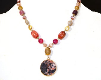 Multi color stone and glass beaded pendant necklace with round stone pendant in rich berry, purple, and gold tone color beads.