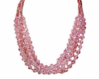 Collana multifilo di perline di vetro rosa realizzata con cinque fili di perline di vetro rosa e perline di semi rosa.