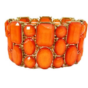May include: A gold and orange stretchy bracelet with large, faceted orange gemstones. The bracelet is made of metal and has a stretchy band.