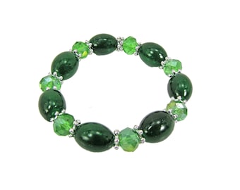 Bracelet extensible en perles de verre vertes avec espaceurs en métal argenté. Il est conçu avec des perles de verre vert foncé et vert clair.