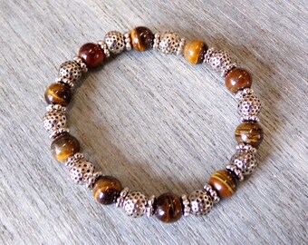 Brown tigers eye genuine stone stretch bracelet created with round silver plated beads and silver spacer beads.