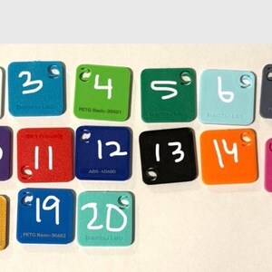May include: Twenty square colour samples are displayed, each with a white number. The samples are in various colours, including brown, white, blue, green, teal, grey, pink, yellow, purple, red, black, orange, and coral.