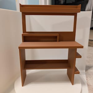 Könnte beinhalten: Ein brauner Holzschreibtisch mit einem Regal darüber. Der Schreibtisch hat zwei Regale unter der Tischplatte und ein kleines Regal auf der Rückseite.