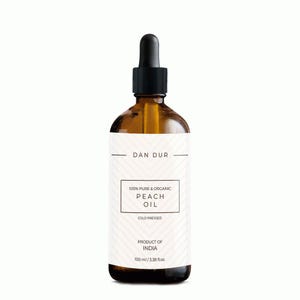 Peut inclure: Une bouteille en verre brun d'huile de pêche avec un compte-gouttes noir. L'étiquette indique "DAN DUR" et "100% Pure & Organic Peach Oil, Cold Pressed, Product of India, 100 ml / 3.38 fl.oz."