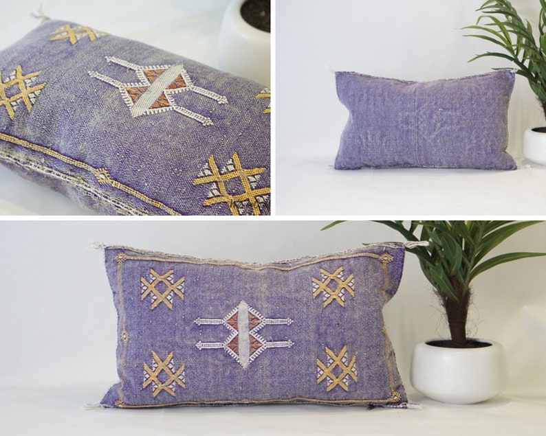 May include: Three purple and white embroidered throw pillows with geometric patterns. The pillows have a light blue background with gold accents.