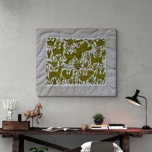 May include: A rectangular wall hanging featuring olive green embroidery on a white fabric background. The design depicts various stylized animals, including deer and birds, interspersed with floral and botanical elements within a border.