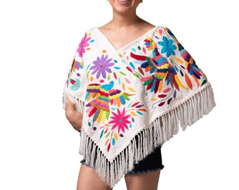 May include: A white poncho featuring a V-neckline and long fringe trim along the hem. The garment is decorated with vibrant, multi-colored floral and bird embroidery in shades of pink, purple, blue, yellow, red, and green across the fabric.