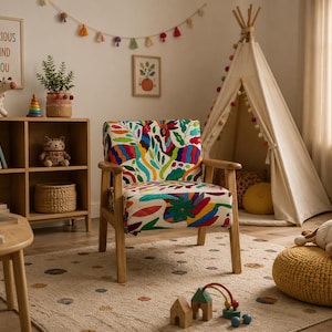 Puede incluir: Un sillón con estructura de madera clara y tapicería con un estampado botánico y animal multicolor y vibrante. La silla tiene un respaldo bajo, reposabrazos rectos y cuatro patas cónicas, mostrando un diseño audaz y detallado.