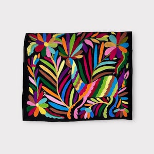May include: A black fabric pillow with colorful embroidery of a bird and floral designs. The embroidery features a variety of colors, including pink, blue, green, yellow, and orange.